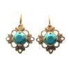 A pair of earrings with gold and turquoise colored stones.