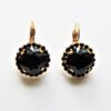 A pair of black earrings with gold trim.