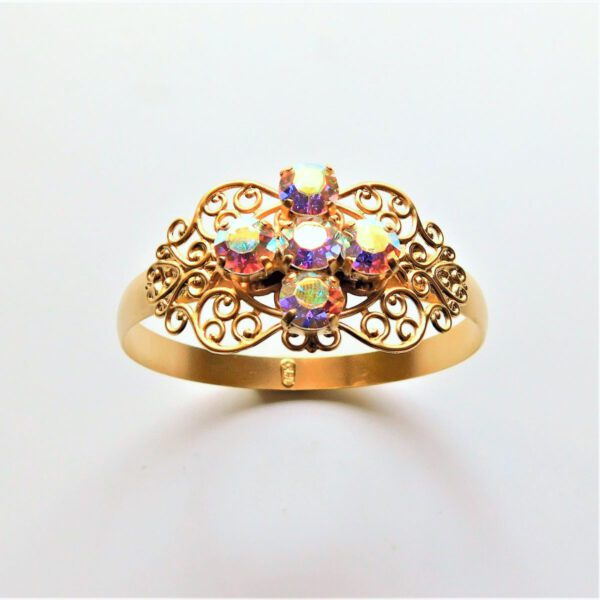 A gold ring with four iridescent stones on it.