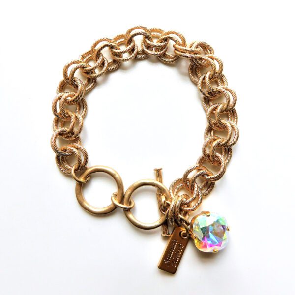 A gold chain bracelet with a charm and a heart.