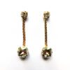 A pair of gold earrings with chains and stones.