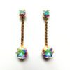 A pair of earrings with chains and iridescent stones.
