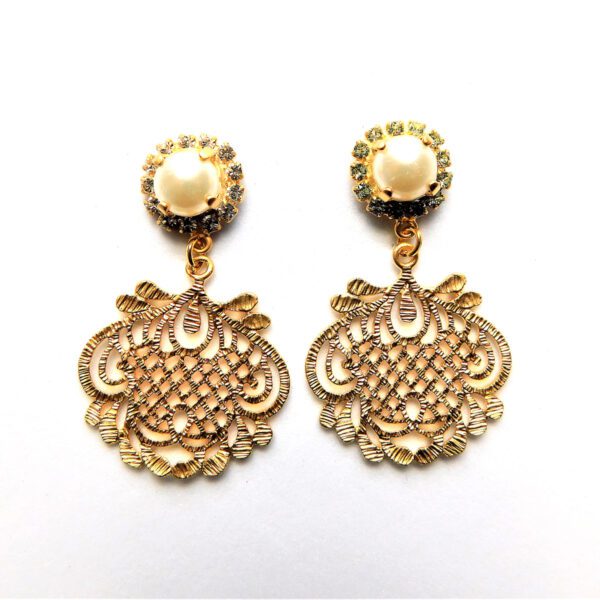 A pair of gold earrings with a large filigree design.