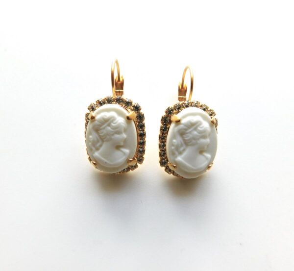 A pair of earrings with white cameo on them.