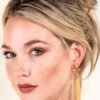 Woman with elegant gold earrings and makeup.