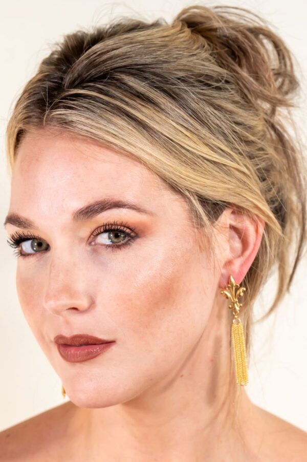 Woman with elegant gold earrings and makeup.