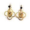 A pair of gold earrings with a woman 's face on them.