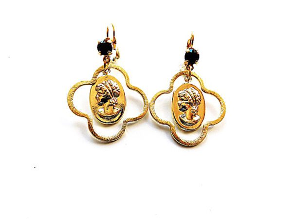 A pair of gold earrings with a woman 's face on them.