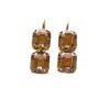 Gold earrings with rectangular brown gemstones.