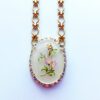 Gold necklace with floral pendant design.