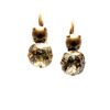 Gold and crystal drop earrings on white background.