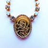 Gold necklace with religious pendant and crystals.