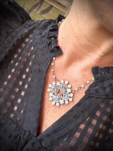 Sparkling floral crystal pendant on black blouse