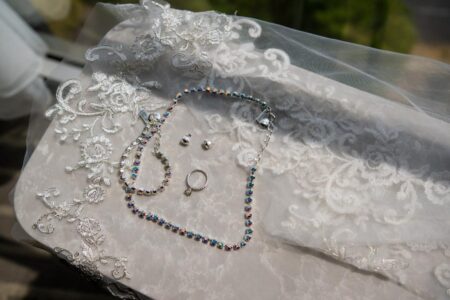 Bridal necklace, ring, and earrings on veil