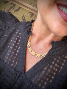Smiling woman wearing gold enamel star necklace