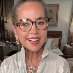 Smiling woman wearing tortoiseshell glasses and necklace